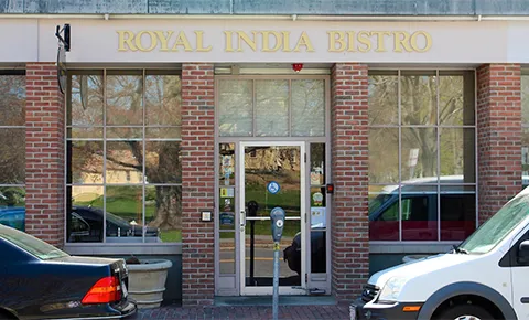 Brick storefront with the illuminated Royal India Bistro sign in Lexington