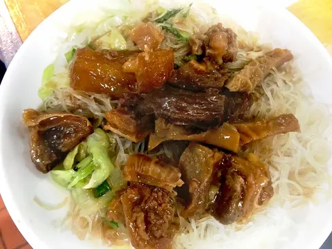 Braised beef brisket and tendon over rice vermicelli with lettuce in a white bowl at Big Fun Café in Quincy