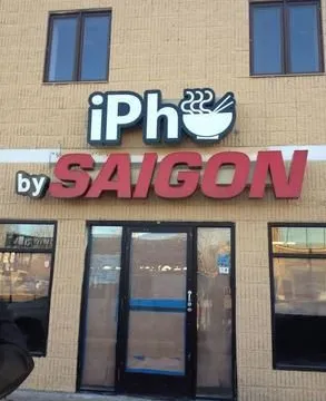 Exterior storefront sign reading 'iPho by Saigon' above the entrance at 704 University Ave W, Saint Paul