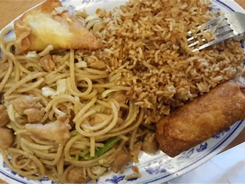 A combination plate of chicken chow mein, fried rice, an egg roll, and a crab rangoon on a classic blue-and-white plate at PongPong Chinese Cuisine in Phoenix