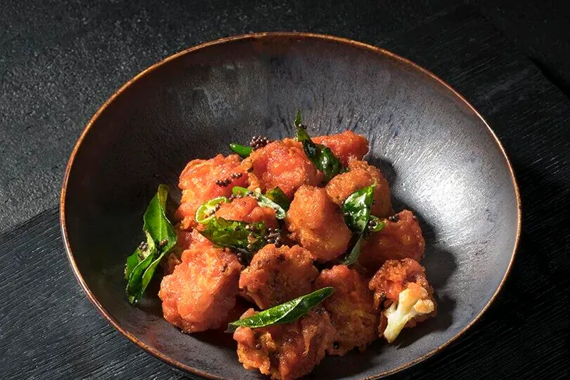 Rasika's cauliflower bezule served in a dark bowl