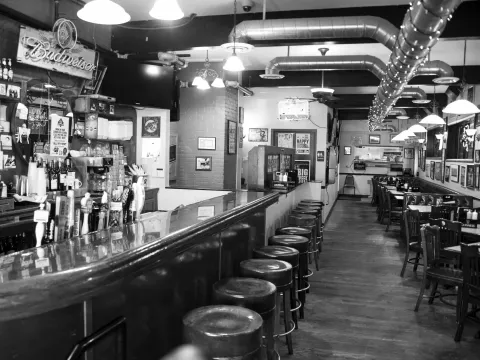 Black-and-white view down the bar and dining room at Casper's & Runyon's Nook in Saint Paul