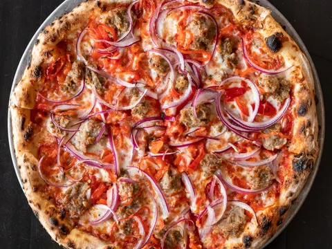 Wood-fired sausage, red onion, and pepper pizza at Pizzeria Lola in Minneapolis