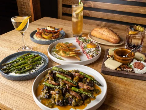 Spread of Spanish tapas including beef tartare, soft-shell crab, grilled asparagus, a cheese board, bread and cocktails at Morcilla in Pittsburgh
