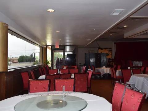 Dining room at Kirin Court in Richardson with round banquet tables, glass lazy Susans and red patterned chairs