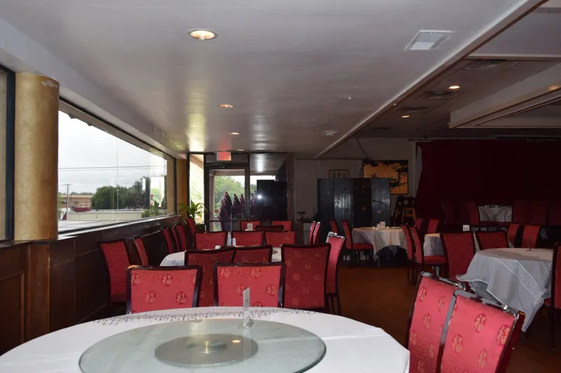 Dining room at Kirin Court in Richardson with round banquet tables, glass lazy Susans and red patterned chairs