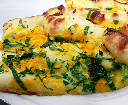 Garlic naan topped with garlic and fresh herbs at Pabla Indian Cuisine