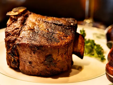 Thick-cut charred steak plated with parsley at Manny's Steakhouse in Minneapolis